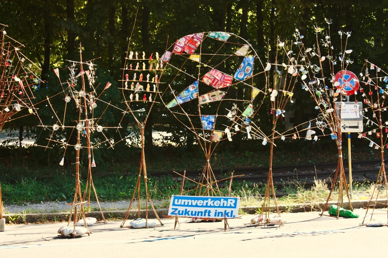 Parkplatzkunst: Abstrahierte Bäume, hergestellt aus Holz- und Drahtobjekten, sowie gebrauchten Aludosen, organisiert von F+F, Sc Parkplatzkunst: Abstrahierte Bäume, hergestellt aus Holz- und Drahtobjekten, sowie gebrauchten Aludosen, organisiert von F+F, Sc