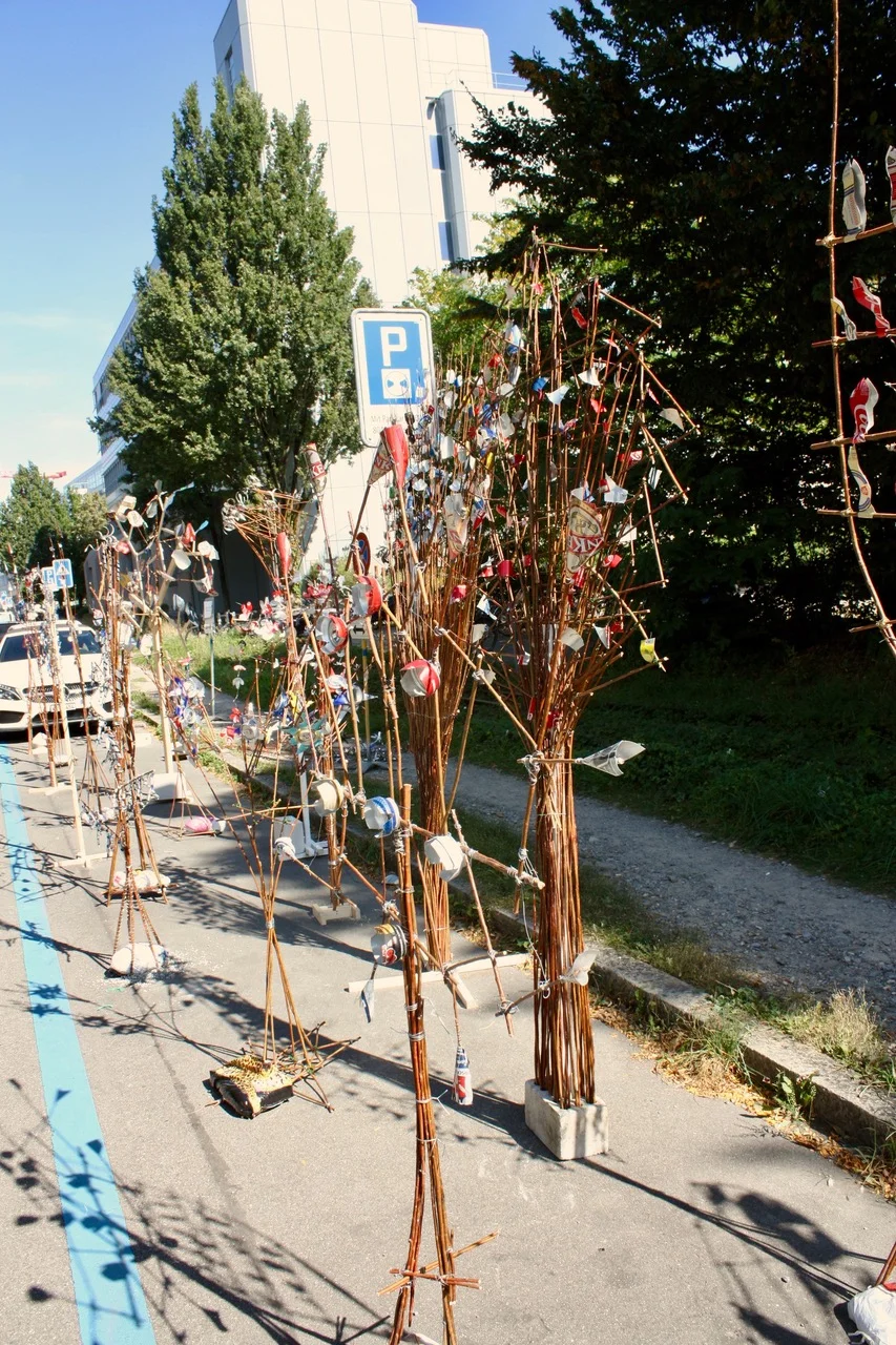 Parkplatzkunst: Abstrahierte Bäume, hergestellt aus Holz- und Drahtobjekten, sowie gebrauchten Aludosen, organisiert von F+F, Sc Parkplatzkunst: Abstrahierte Bäume, hergestellt aus Holz- und Drahtobjekten, sowie gebrauchten Aludosen, organisiert von F+F, Sc