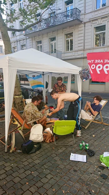 PARK(ing) Day 2021, Zürich, Zähringerplatz. Kleiner kollektiver Aufenthalt mit Teppich, Fahnen und Stühlen